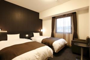 三岛市多美迎三岛酒店的酒店客房设有两张床和窗户。