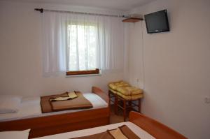 Draga BašćanskaHoliday Home Garina的小房间设有两张床和电视