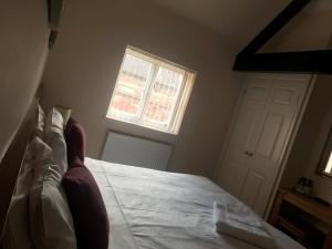 亚瑟斯通亚瑟斯敦红狮酒店的一间卧室配有一张带白色床单的床和一扇窗户。