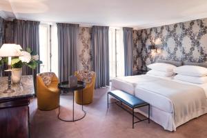 巴黎多瑙河圣日耳曼酒店的卧室配有一张床和一张桌子及椅子