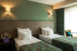 布拉索夫Victoria Bulevard Hotel的酒店客房设有两张床和窗户。