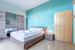 特拉森海德Bella Vita的一间卧室设有两张床和蓝色的墙壁
