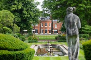 阿斯科特Royal Berkshire的花园前的雕像,花园内有一座建筑