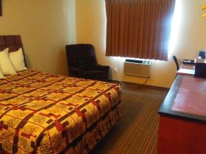 格兰福克骑士旅馆 - 格兰德福克斯的配有一张床和一把椅子的酒店客房