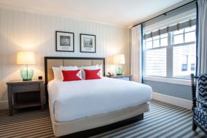 格洛斯特Beauport Hotel Gloucester的一间卧室配有一张带红色枕头的大床