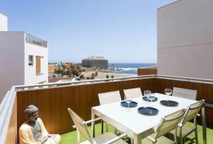 厄尔梅达诺Sea View Apartment in El Médano with pool & private parking space的海滩阳台的桌椅