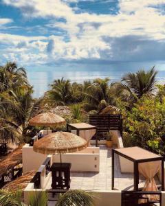 珀拉什奇亚Caribbean Beach Cabanas - A PUR Hotel的一个带桌子和遮阳伞的庭院和大海