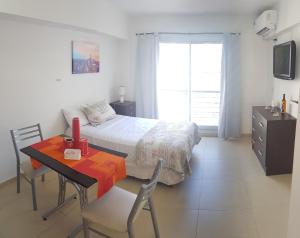 布宜诺斯艾利斯Aguero y Av. Las Heras的卧室配有1张床、1张桌子和1张桌子以及椅子。