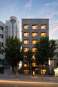 首尔Hostel CLEO Seoul Hongdae的前面有树木的高楼