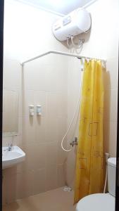 茂物Womy Homy的浴室设有黄色淋浴帘和淋浴
