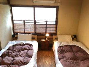 直岛町Guest house Roji to Akari的带大窗户的客房内的两张床