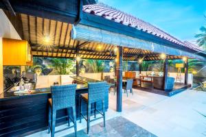 吉利特拉旺安吉利别墅酒店的户外庭院,设有配备蓝椅的酒吧