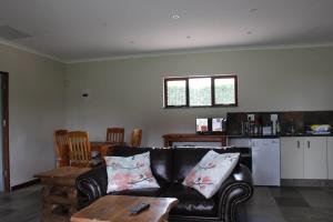 德尔斯特鲁姆Misty Cottage的客厅配有黑色沙发和桌子