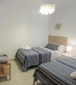 科尔多瓦Paseos por Córdoba的一间卧室配有两张床和吊灯。