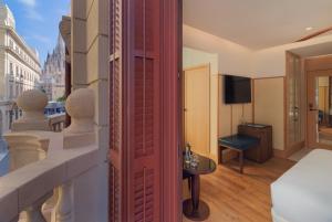 巴塞罗那H10麦迪逊四星素普酒店的客房设有阳台、一张床和电视。