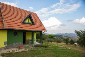 兹拉蒂博尔Vikendica MM的绿色和黄色的房屋,有红色屋顶