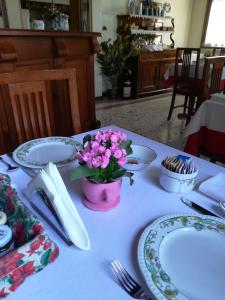 波图格鲁洛阿尔伯格梅里迪娜酒店的一张桌子,上面有盘子和花瓶
