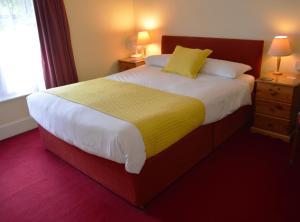 索尔兹伯里维多利亚旅舍的一间卧室配有一张带黄色毯子的大床