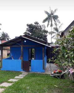佩尼多Chalé saí azul的蓝色的房子,设有门廊和院子