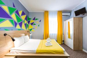 利沃夫Blum Hotel的一间卧室设有一张床和色彩缤纷的墙壁