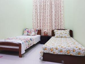 双溪大年Islamic Homestay Sungai Petani的一间卧室配有床、椅子和窗帘