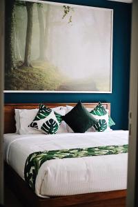 Ban Huai Sok Noi23 Degree Khaoyai 2 Bedroom Tropical style的一间卧室配有带枕头的床铺和绘画