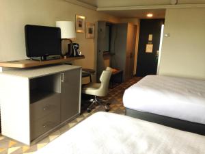皮茨菲尔德Holiday Inn & Suites Pittsfield-Berkshires, an IHG Hotel的酒店客房配有一张床和一张书桌及一台电视
