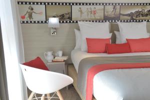 佩罗斯-吉雷克班斯贝斯特韦斯特SPA酒店的一间卧室配有一张带红色枕头的床和一把椅子