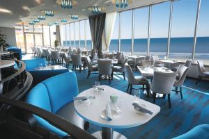 大西洋城康纳赌场和度假酒店的餐厅设有桌椅,背景为大海