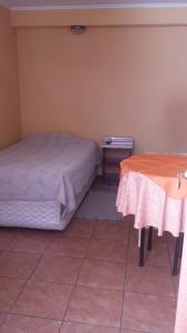卡拉马Hotel Don Alfredo的一间卧室配有两张床和一张桌子
