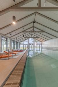 霍尔斯泰因地区诺伊斯塔特ARBOREA Marina Resort Neustadt的一座带游泳池和长凳的大型建筑