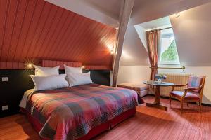 尼约勒拉夏贝尔圣马丁酒店的一间卧室配有一张床、一张桌子和一个窗户。