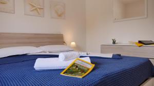 佩斯基奇Spiaggia Dorata的一间卧室配有一张蓝色的床,上面有一本书