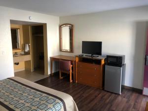 埃尔卡洪北门汽车旅馆的酒店客房配有一张床和一张书桌及一台电视