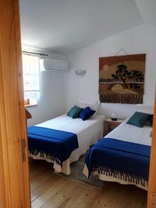Montes da SenhoraREFÚGIO DO RAPOSO/CASA VEGA的一间卧室配有两张蓝色床单