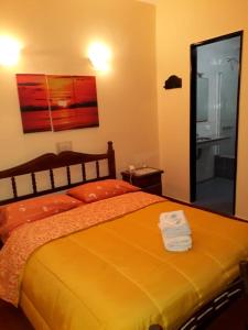 General San MartínHotel Paris的一间卧室配有一张橙色大床和镜子