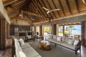 马洛洛斐济第六感度假酒店的开放式客厅配有沙发和桌子
