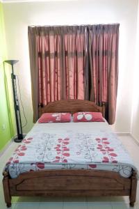 芙蓉Homestay Jasmin Indah, Senawang (free wifi)的一间卧室配有一张带粉红色窗帘的大床