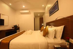 KunnamkulamVictory Inn Park Residency的酒店客房配有一张带枕头的大型白色床。