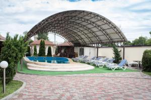 波尔塔瓦Restoran-hotel Stariy Melnik的一个带躺椅的庭院和一个游泳池