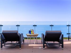 济州市济州格拉贝尔酒店的海景庭院设有两把椅子和一张桌子