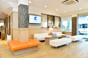 Neyagawa大阪寝屋川新指挥官酒店的一间设有白色家具和平面电视的等候室