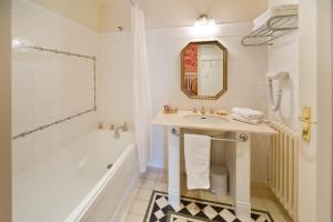 克洛茨皮克塔城堡酒店的一间带水槽、浴缸和镜子的浴室