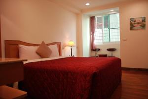 白河丽汤温泉渡假山庄的一间卧室配有一张带红色毯子的床和窗户。