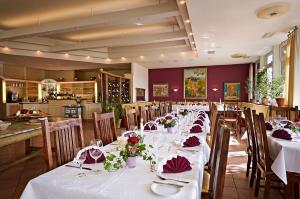 奥伊廷奥伊廷老路政酒店的用餐室配有白色的桌椅和鲜花