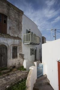 EmporeiósPyrgos Stone House的白色的建筑,旁边设有阳台