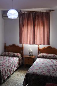 圣何塞德拉林科纳达圣安娜旅馆的一间卧室配有两张床和一张带台灯的桌子
