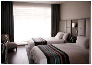拉巴斯格兰德之家酒店的酒店客房设有两张床和窗户。