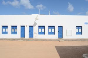 塞博河畔卡莱塔Apartamentos El Marinero - Iglesia的白色的建筑,有蓝色的门