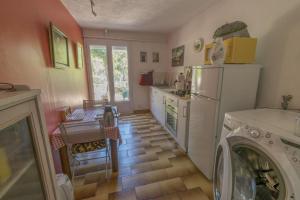 昂叙埃拉雷东Villa Violette的厨房配有冰箱、洗衣机和烘干机